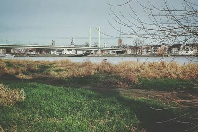 Bridge over river in city against clear sky