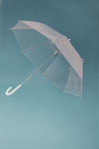 Low angle view of umbrella against blue sky