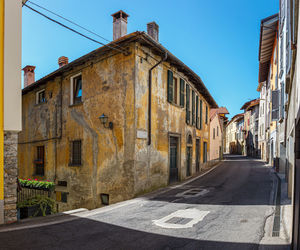 Empty road amidst buildings against clear sky