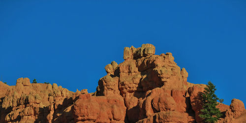 Low angle view of rock formations against blue sky