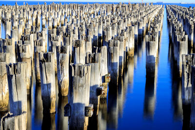 Close-up of pier wooden posts in row
