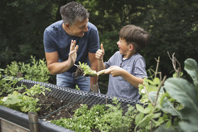 Siblings playing with plants