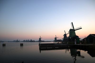 Traditional windmill against sky at sunset