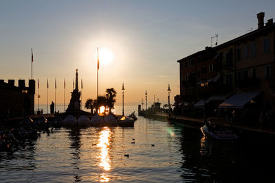 Boats in canal at sunset