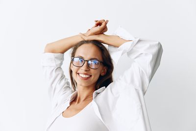 Portrait of female doctor holding stethoscope against white background