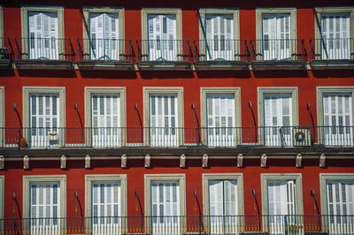 Old building with colorful facade and windows with balustrade on the plaza mayor in madrid, spain.