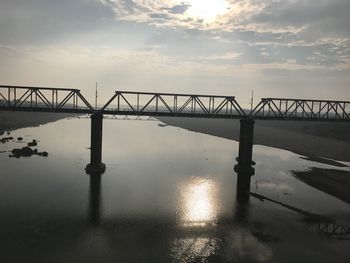 Bridge over river against sky during sunset