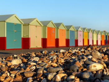 Pebbles on beach against colorful huts