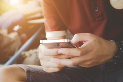 Midsection of man using mobile phone