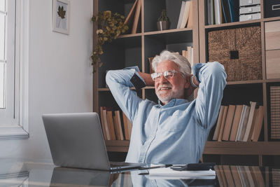 Man using mobile phone while sitting on table