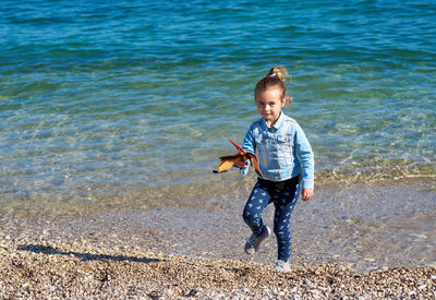 Full length of girl holding toy at beach