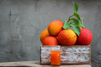 Close-up of orange fruits on table against wall