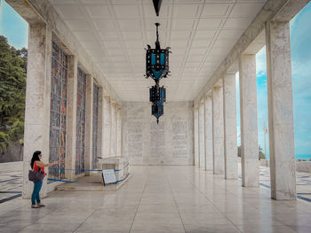 Rear view of man walking in corridor of building