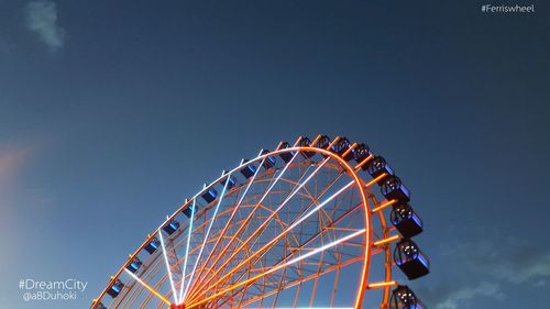 Low angle view of ferris wheel against blue sky