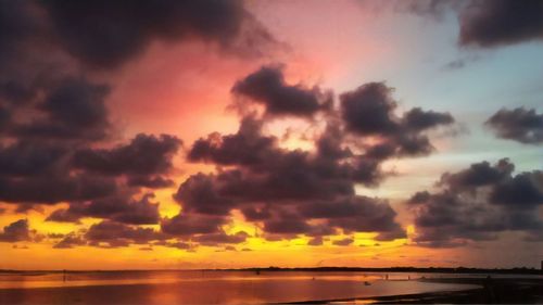 Scenic view of sea against dramatic sky during sunset