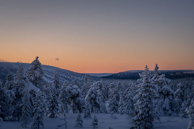 Scenic view of snowcapped mountains against clear sky during sunset