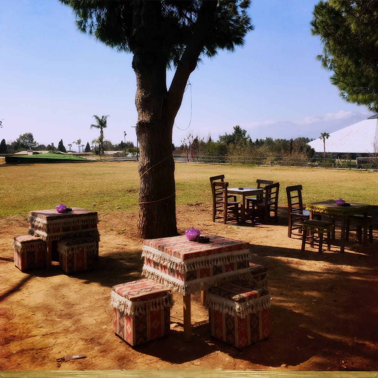 CHAIRS AND TABLE ON FIELD AGAINST SKY