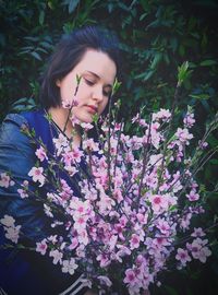 Beautiful young woman by purple flowering plants