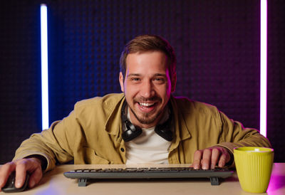 Portrait of young man using mobile phone at home