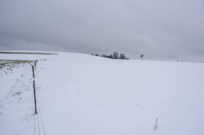 Scenic view of snow covered field against sky