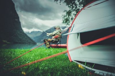 Tent at grassy lakeshore