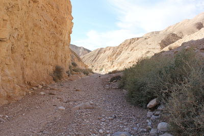 Footpath amidst rocky mountains at wadi og
