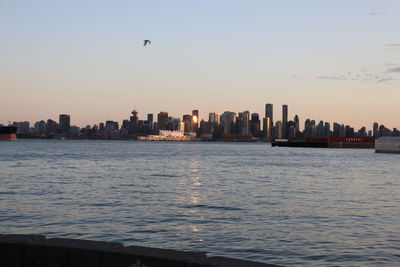 View of sea and buildings against sky during sunset