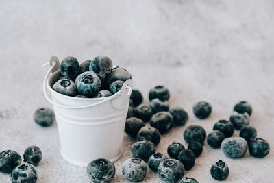 Frozen blueberries in small bucket on concrete background. healthy organic seasonal fruit 