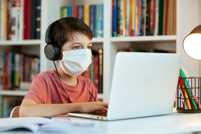 Portrait of boy using phone while sitting on table