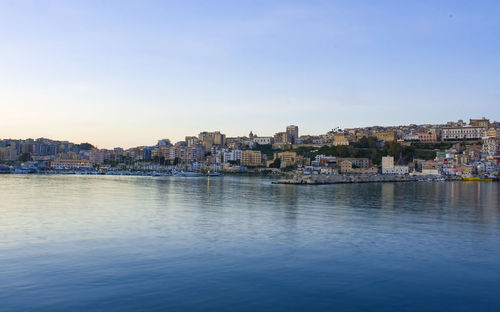 View of townscape by sea against clear sky
