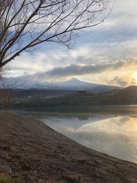 Scenic view of lake by mountains against sky