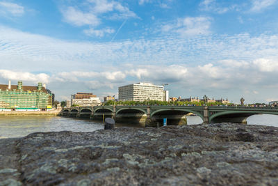 Westminster bridge over thames river against sky in city