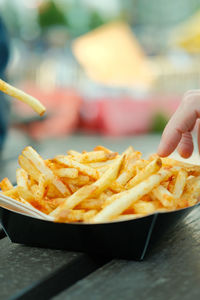 Close-up of hand picking fries