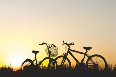 Silhouette of bicycles against clear sky during sunset