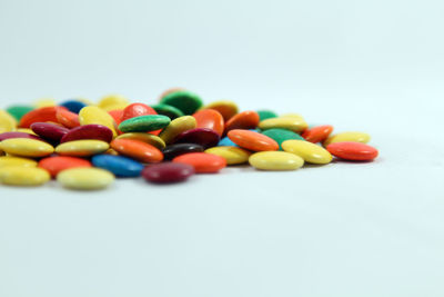 Close-up of multi colored candies against white background