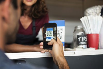 Cropped image of customer paying through smart phone at food truck