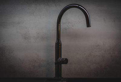 Close-up of electric lamp on table against wall