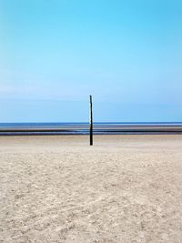 Scenic view of beach against clear blue sky