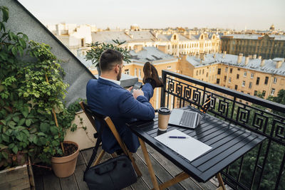 Male professional using smart phone in office balcony