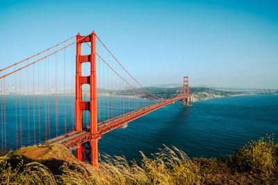View of suspension bridge against clear blue sky