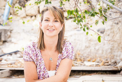 Portrait of smiling mature woman sitting against rock formation