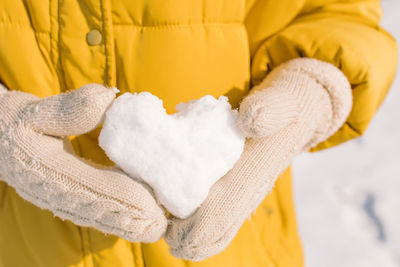Close-up of hand holding yellow during winter