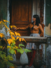 Full length of woman standing outside abandoned house