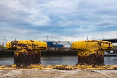 Rusty yellow bollards at harbor