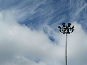 Low angle view of floodlight against cloudy sky