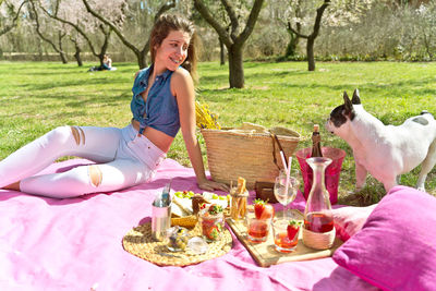 Portrait of young woman with dog on table