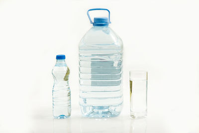 Close-up of empty glass bottle on table against white background