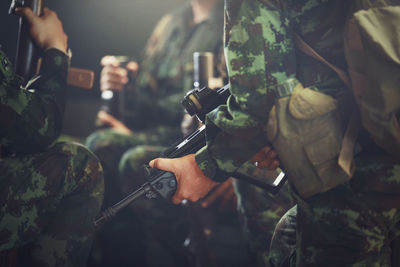 Midsection of soldiers with guns