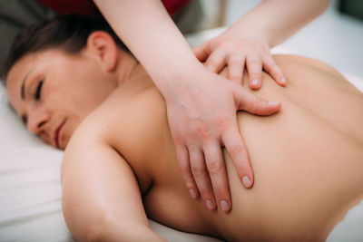 Back massage in a massage salon, woman having a relaxing back massage.