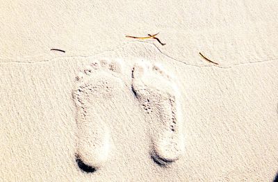 Close-up of footprints on sand at beach